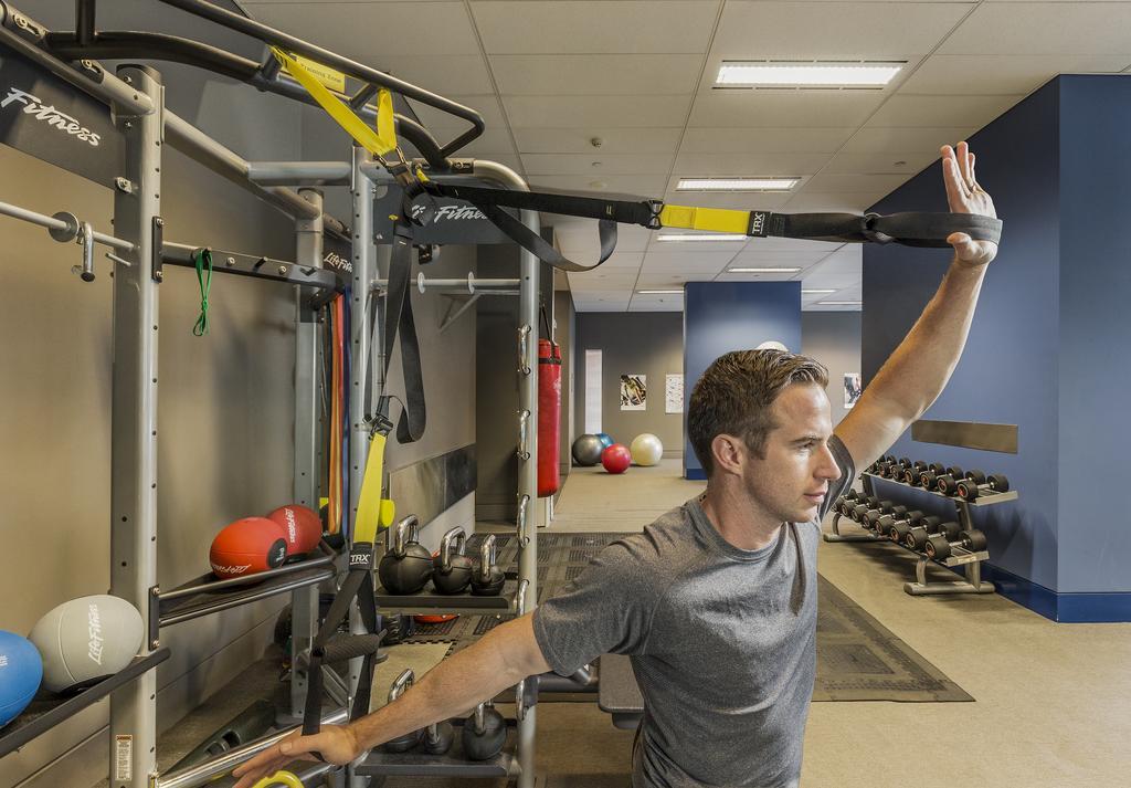 Fraser Suites Sydney Esterno foto A man using a TRX suspension trainer